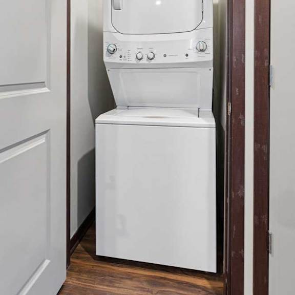 Thumbnail 23 of 23 A stacked full-sized washer and dryer in a laundry room.