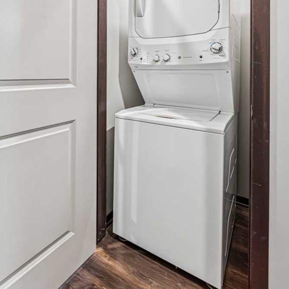 Thumbnail 13 of 15 A stacked full-sized washer and dryer in a laundry room.