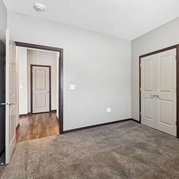 Thumbnail 18 of 19 A carpeted bedroom with two double-door closets.