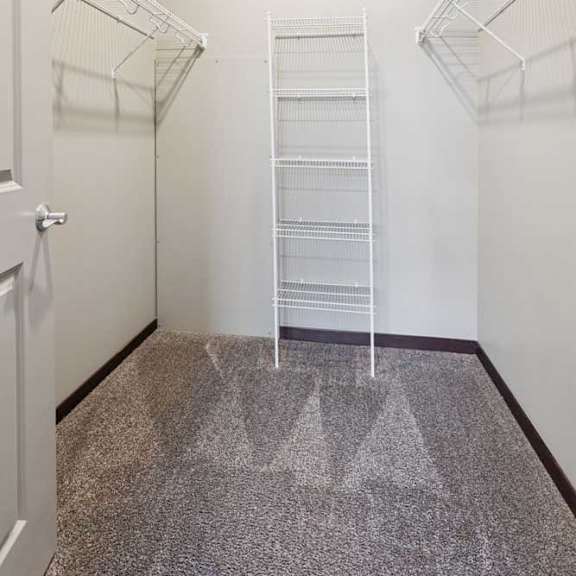 Thumbnail 13 of 19 An oversized walk-in closet with several built-in wire shelves.