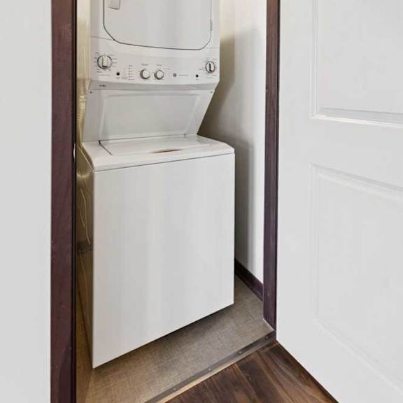 Thumbnail 16 of 19 A stacked full-sized washer and dryer in a laundry room.