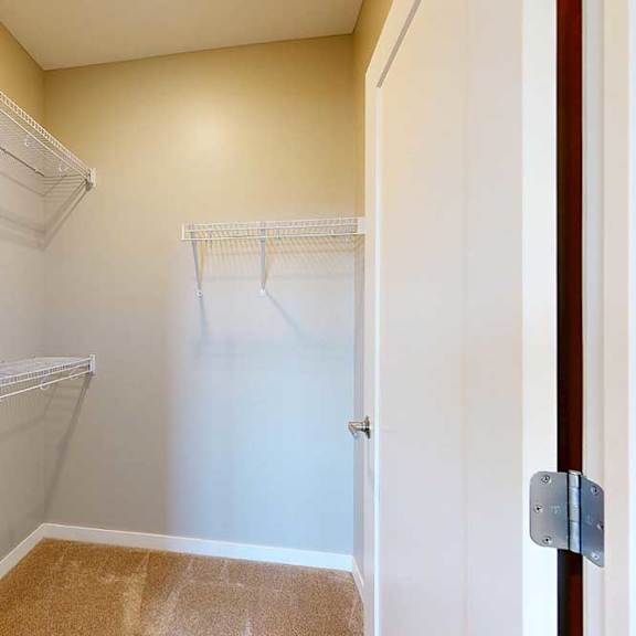 Thumbnail 21 of 27 A spacious walk-in closet with built-in wire shelving.