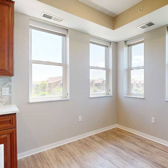 Thumbnail 14 of 27 A dining room with hardwood-style flooring and several large windows for plenty of natural light.