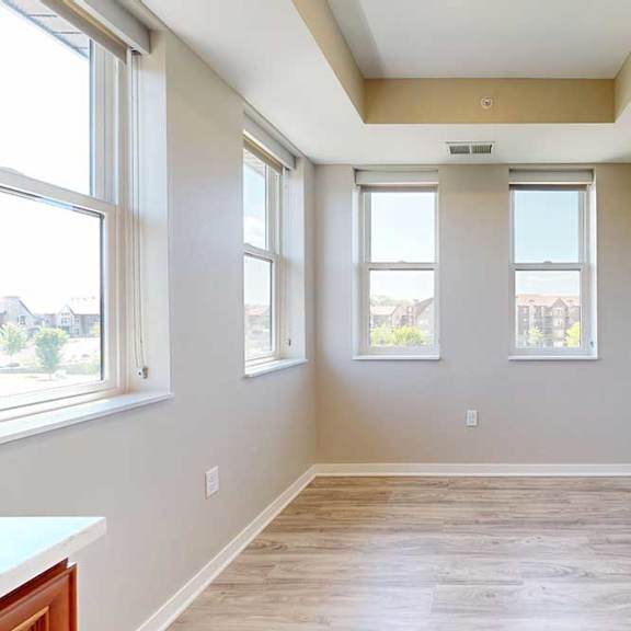 Thumbnail 15 of 27 A dining room with hardwood-style flooring and several large windows for plenty of natural light.