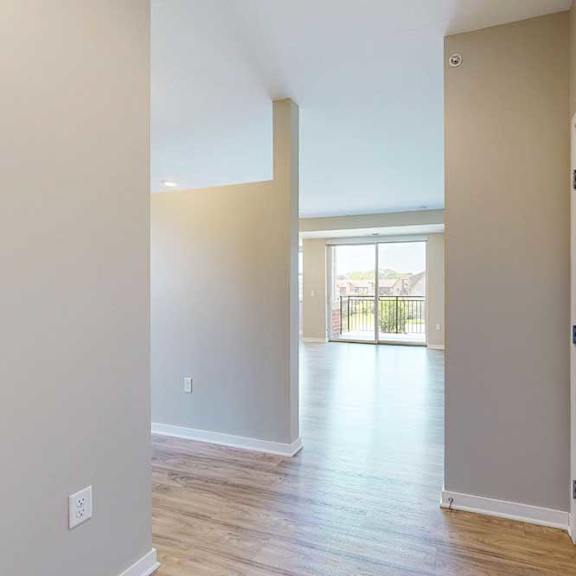 Thumbnail 4 of 27 An enrty way open to a living room and a hallway connecting to a bedroom.