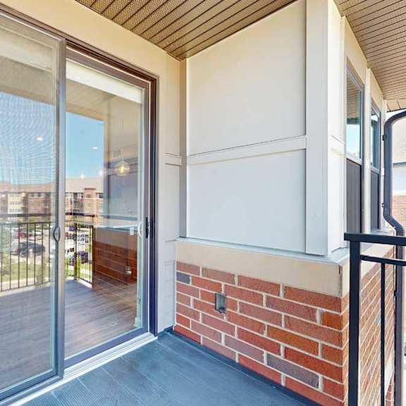 Thumbnail 9 of 29 A balcony with a sliding glass door to the living room and a screen door.