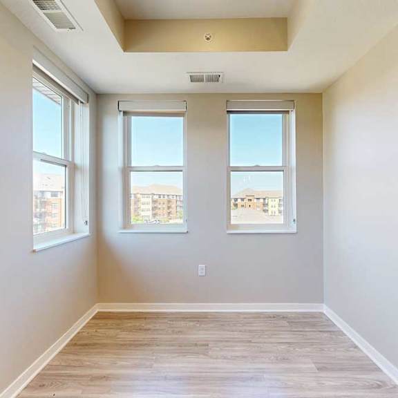 Thumbnail 15 of 29 A dining area with several large windows and hardwood-style flooring.