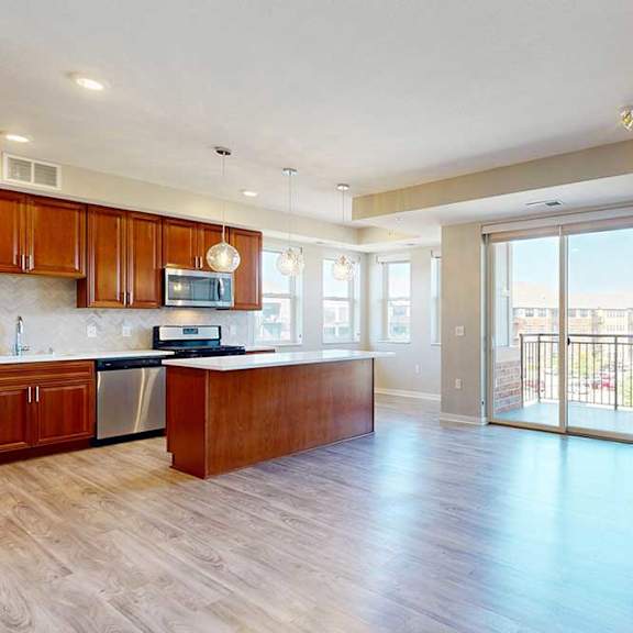 Thumbnail 5 of 29 A spacious living room with hardwood-style flooring, a built-in fireplace, and a sliding glass door to a balcony.