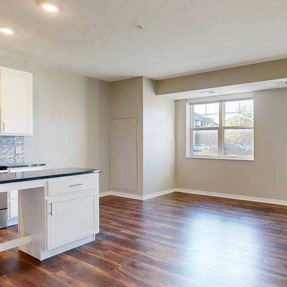 Thumbnail 8 of 13 A living area with hardwood-style flooring and large windows for plenty of natural light.