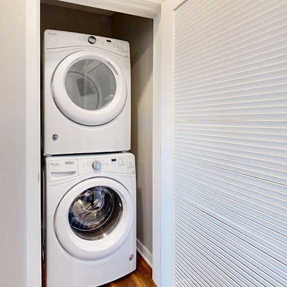 Thumbnail 13 of 13 A stacked in-unit laundry washer and dryer in a closet.
