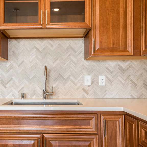 Thumbnail 3 of 12 Ascend at Woodbury luxury apartment with herringbone backsplash in kitchen