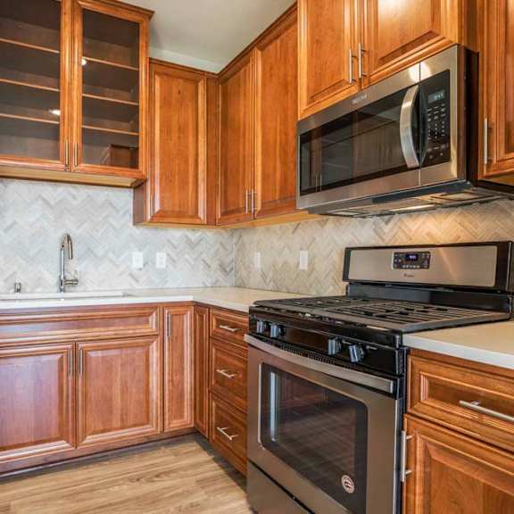 Thumbnail 4 of 12 Premium design scheme with custom cabinetry and herringbone backsplash at Ascend at Woodbury MN 55129 new luxury apartments