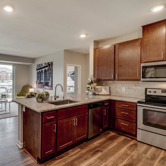 Thumbnail 9 of 19 Luxury apartment with dark cabinetry and granite countertops at Ascend at Woodbury MN 55129 new luxury apartments