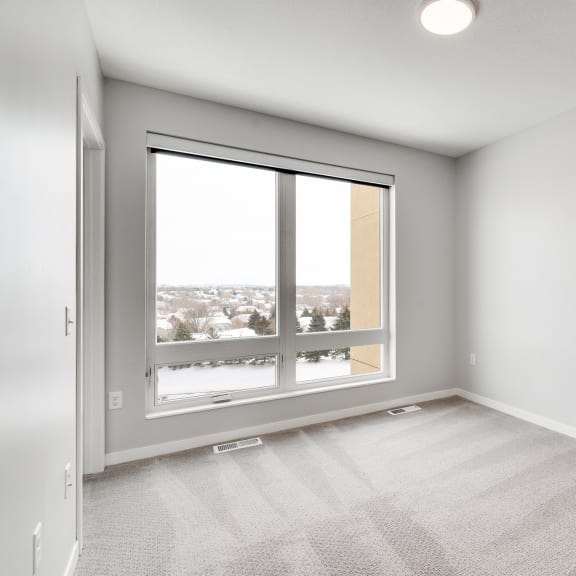 Thumbnail 10 of 16 Spacious bedroom with large window and natural light at Aspire at CityPlace in Woodbury, Minnesota