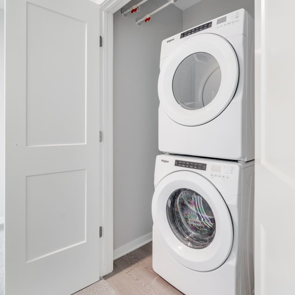 Thumbnail 13 of 16 Stacked washer and dryer in laundry closet in luxury apartment home at Aspire at CityPlace in Woodbury, Minnesota