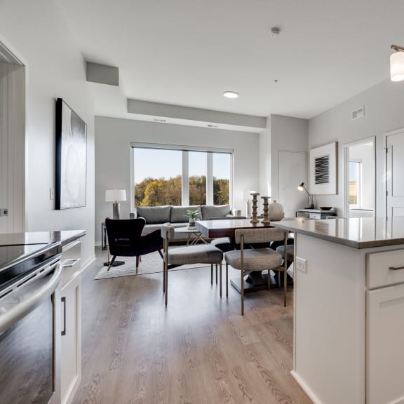 Thumbnail 4 of 15 Kitchen island and living room at luxury apartment in Woodbury MN 55125