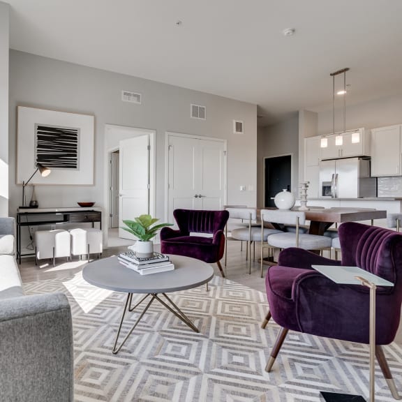 Thumbnail 6 of 15 Furnished living room with high ceilings looking into the kitchen at Aspire at CityPlace Woodbury MN 55125