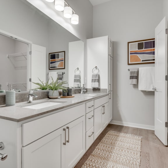 Thumbnail 11 of 15 Bathroom with dual vanities and French doors in a luxury two bedroom apartment in Woodbury MN 55125