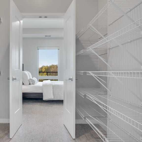 Thumbnail 9 of 15 Large walk in closet with double doors and wire shelves on each side in 2 bedroom apartment in Woodbury MN 55125