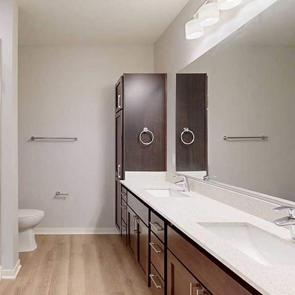 Thumbnail 17 of 19 A bathroom with a toilet, sink, and mirror.