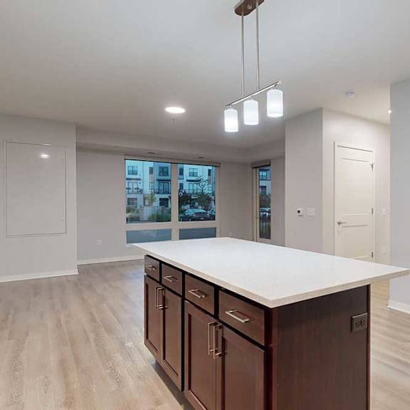 Thumbnail 14 of 19 A kitchen with brown cabinets and a white countertop.