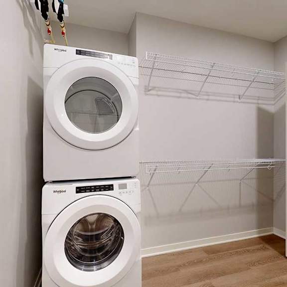 Thumbnail 13 of 19 Two washing machines are stacked on top of each other in a laundry room.