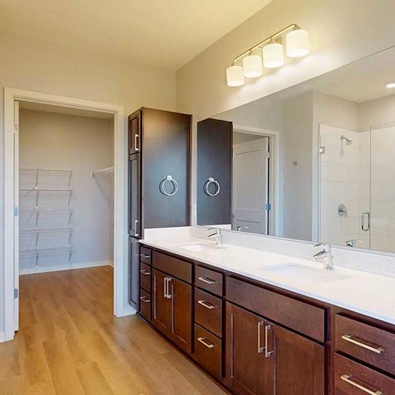 Thumbnail 16 of 27 A bathroom with a vanity and a large mirror.