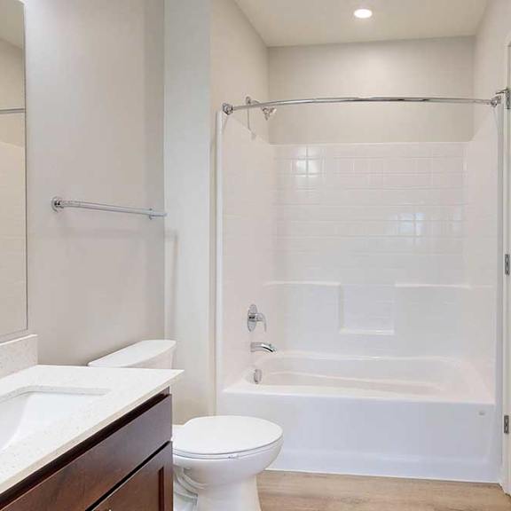 Thumbnail 13 of 27 A white bathroom with a toilet, sink, and bathtub.