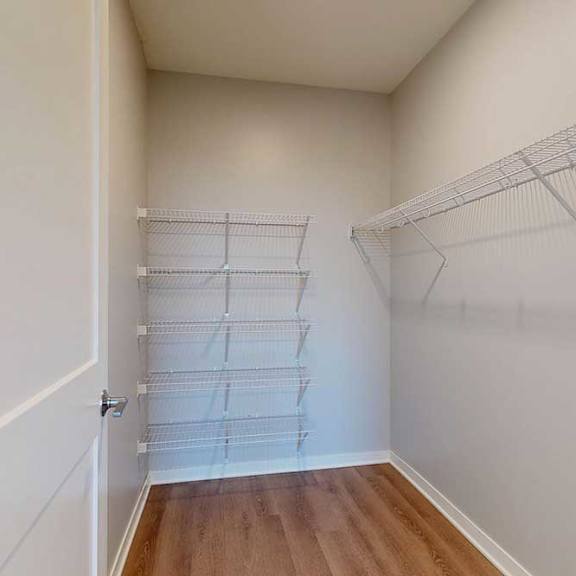 Thumbnail 26 of 27 A white closet with a door and shelves.