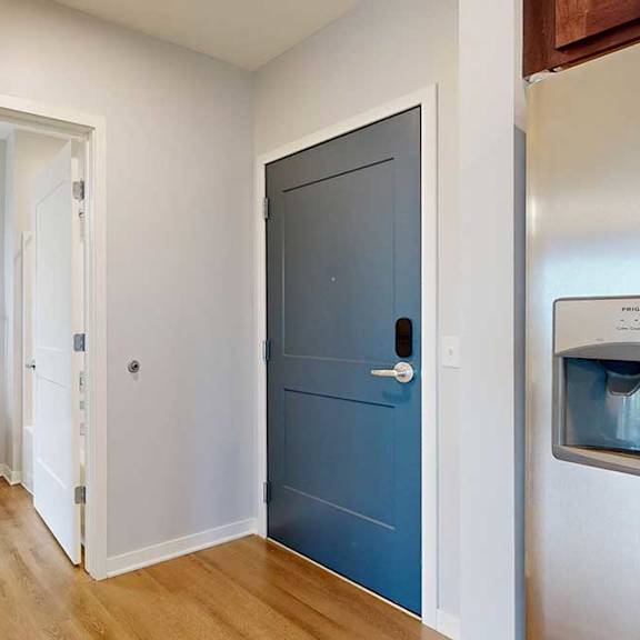 Thumbnail 8 of 27 A bathroom with a toilet and a blue door.