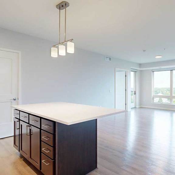 Thumbnail 27 of 27 A kitchen with dark wood cabinets and a white countertop.