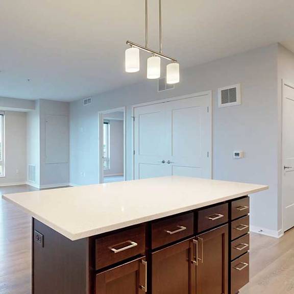 Thumbnail 14 of 27 A kitchen with a large island and wooden cabinets.