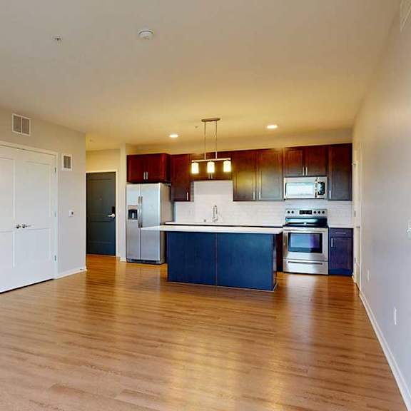 Thumbnail 22 of 27 A kitchen with dark wood cabinets and stainless steel appliances.