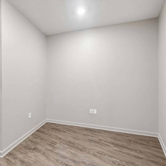 Thumbnail 10 of 17 Unfurnished den with wood-look flooring, recessed lighting, and a versatile layout suitable for a home office or study area.