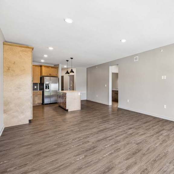 Thumbnail 8 of 17 Bright open living room with wood-look flooring, recessed lighting, and a glass door leading to the private balcony.
