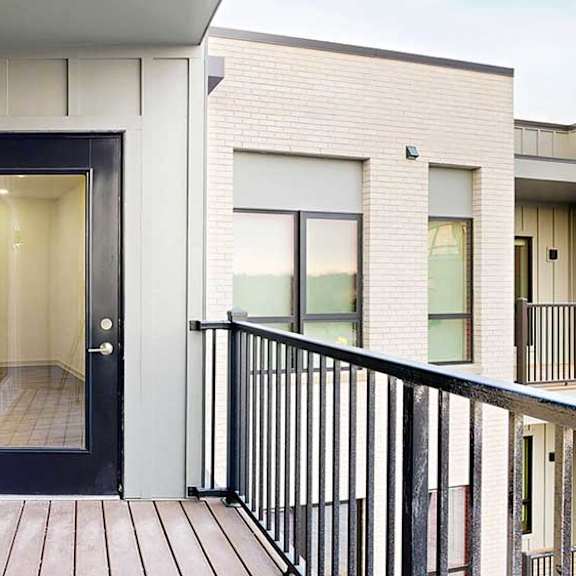 Thumbnail 14 of 29 a balcony with a black windowed door to the living room and a window into the bedroom
