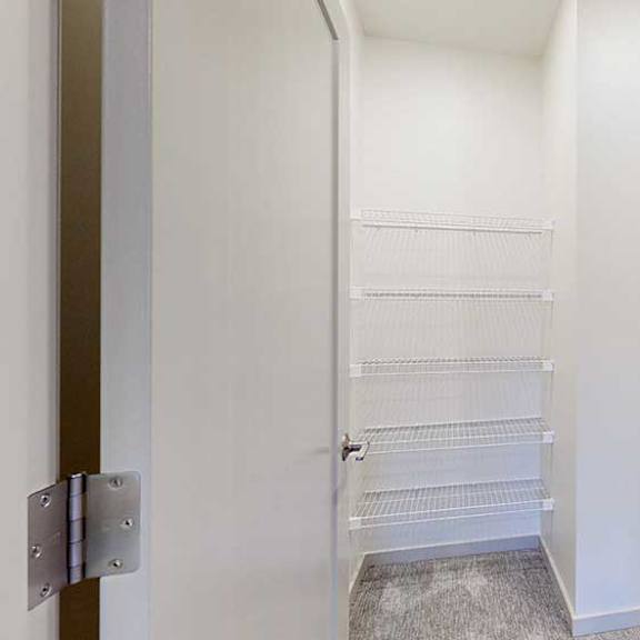 Thumbnail 23 of 29 a large L-shaped walk-in closet with built-in shelving and hanging space