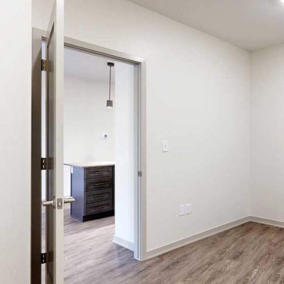 Thumbnail 18 of 29 a den space with hardwood flooring and white walls