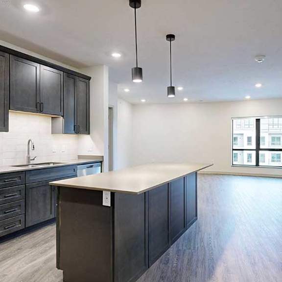 Thumbnail 2 of 29 an open concept living room and kitchen with dark wood cabinets and light quartz countertops