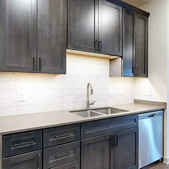 Thumbnail 6 of 29 a large L-shaped kitchen with dark wooden cabinets, a light tile backsplash, stainless steel appliances, and a large walk-in pantry
