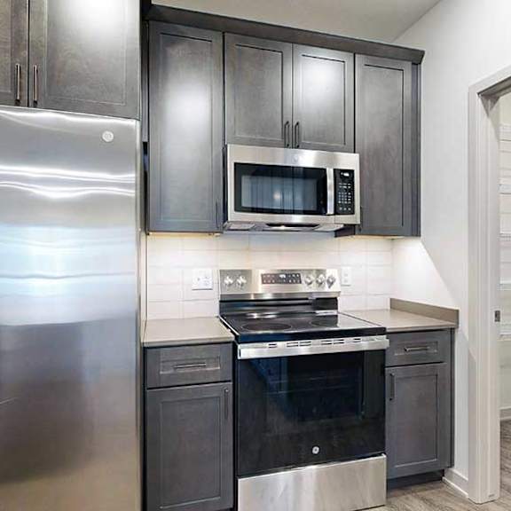 Thumbnail 4 of 29 a modern kitchen with dark wood cabinets, stainless steel appliances, and a large walk-in pantry