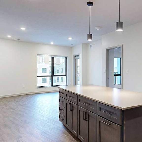 Thumbnail 7 of 29 a large kitchen island with quartz countertops in front of a spacious living room