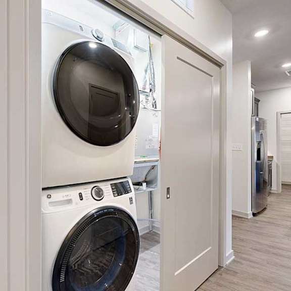 Thumbnail 28 of 29 a stackable washer and dryer in a double door closet in the front hallway