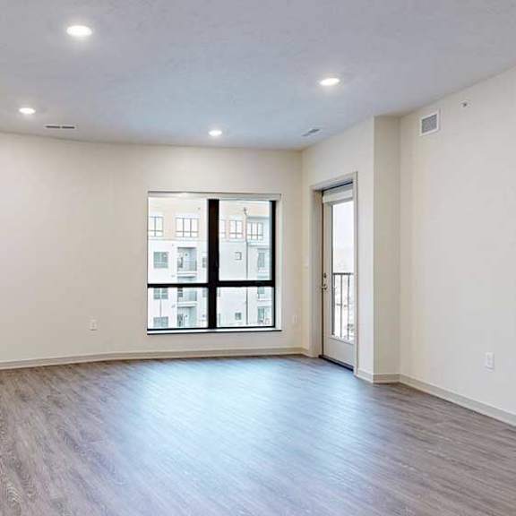 Thumbnail 10 of 29 a spacious living room with a large window and a windowed door to a balcony