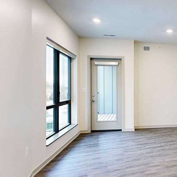 Thumbnail 11 of 29 a spacious living room with wood flooring and white walls