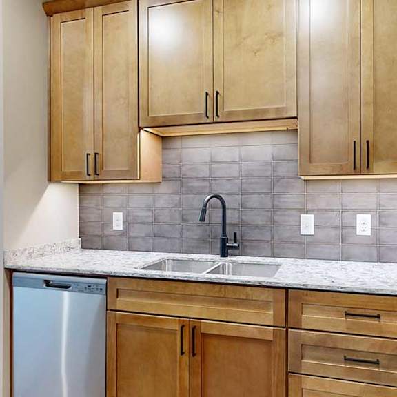 Thumbnail 7 of 29 a kitchen with light brown cabinets, quartz countertops, and a tile backsplash