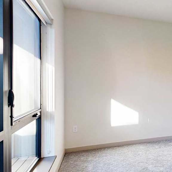 Thumbnail 19 of 28 a bedroom with carpeted flooring, a ceiling fan, a large window, and a walk-in closet