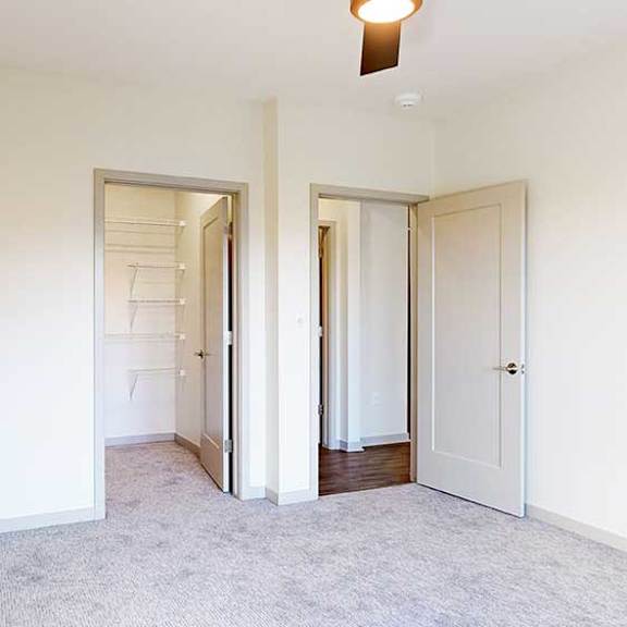 Thumbnail 20 of 28 a bedroom with carpeted flooring, a ceiling fan, and a walk-in closet