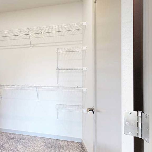 Thumbnail 21 of 28 a walk-in closet with built-in shelving and hanging space on the far and left walls