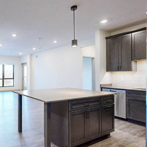 Thumbnail 2 of 28 a modern kitchen with a large central island and a door to the den space